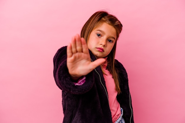 Kleines kaukasisches Mädchen lokalisiert auf rosa Stehen mit ausgestreckter Hand, die Stoppschild zeigt, das Sie verhindert.