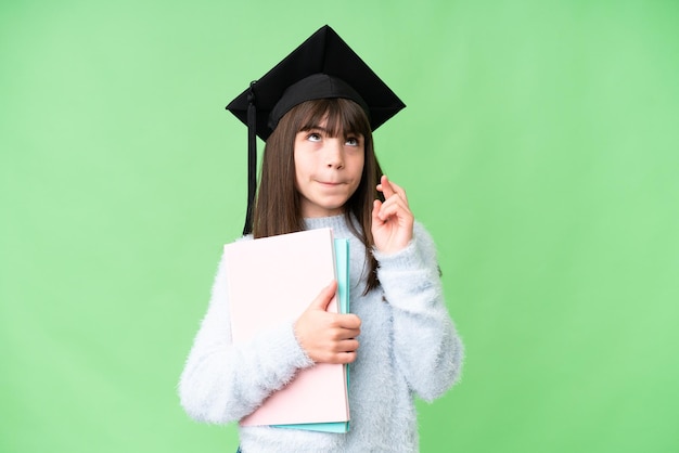 Kleines kaukasisches Studentenmädchen über isoliertem Hintergrund mit gekreuzten Daumen und dem Wunsch nach dem Besten