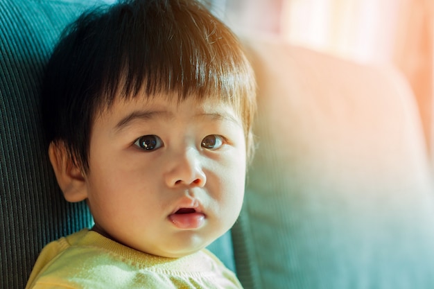 Foto kleines kind - baby, das auf sofa sitzt