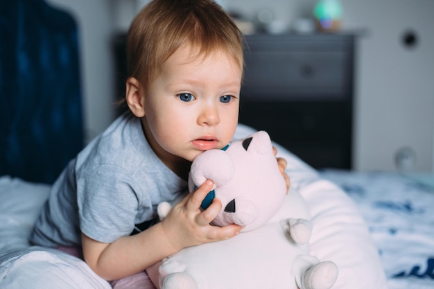 Kleines Kind hat Spaß beim Spielen mit Stofftieren auf der Couch zu Hause