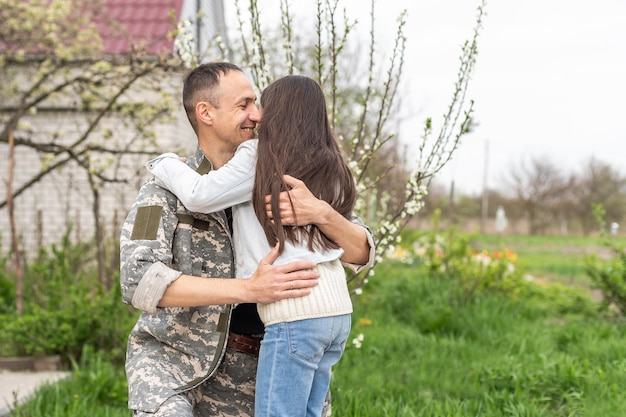 Kleines Kind ist sehr glücklich, dass ihr Vater von der Armee zurückgekommen ist. Kleines Kind umarmt ihren Vater.