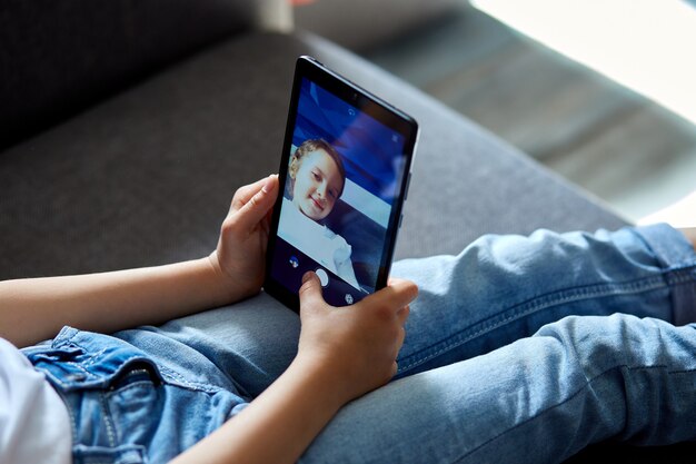 Kleines Kind Mädchen zu Hause sprechen Video mit Tablet-Treffen, Online-Anruf Freund