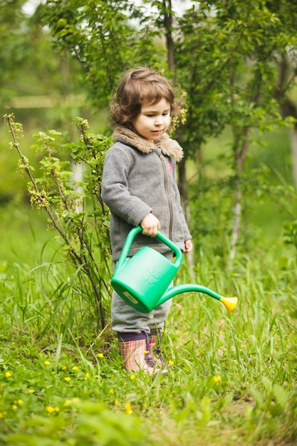 Kleines Kind mit Gießkanne im Garten