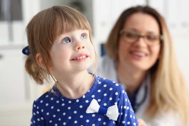 Kleines Kind mit Mutter am Kinderarztempfang. Porträtbabyhilfe der körperlichen Prüfung nettes Säuglingsgesunder Lebensstil-Bezirk ringsum Kinderkrankheitskliniktestqualität und Babykonzept