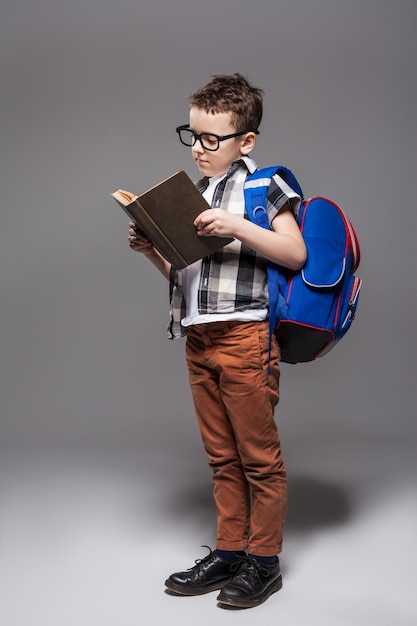Kleines Kind mit Schultasche und Buch