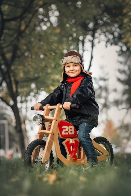 Kleines Kind sitzt auf einem Laufrad in Oberbekleidung