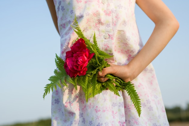 Kleines Kindermädchen, das Blumenstrauß von Blumen hält.