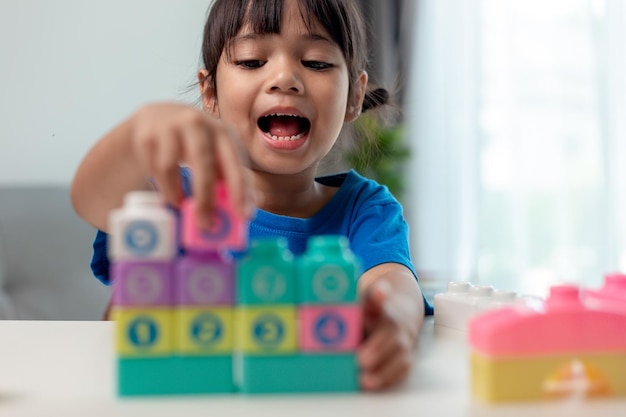 Kleines Kindermädchen, das bunte Blöcke spielt