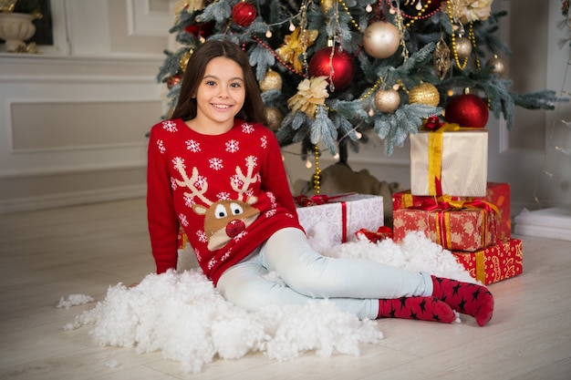 Kleines Kindermädchen mag Weihnachtsgeschenk. Weihnachten. Kinder genießen den Urlaub. Frohes neues Jahr. kleines glückliches Mädchen zu Weihnachten. Der Morgen vor Weihnachten. Neujahr. Kleiner Weihnachtszauber.