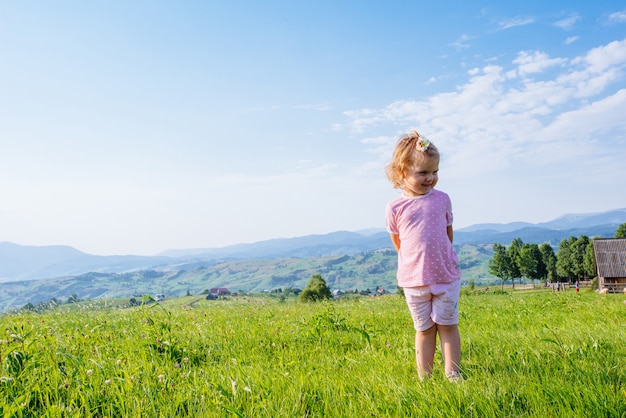 Kleines Kleinkindmädchen, das in einem schönen Feld läuft