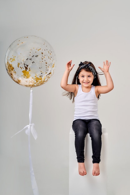 Kleines lustiges Mädchen mit einem Ballon.