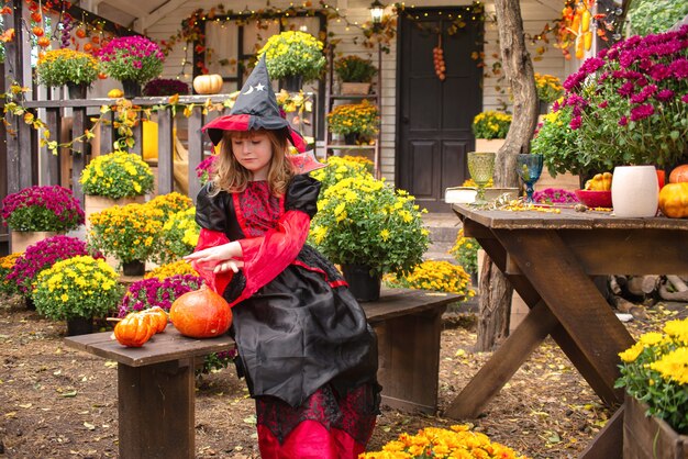 kleines Mädchen als Hexe verkleidet feiert Halloween