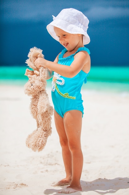 Kleines Mädchen am tropischen weißen Strand, der Sandburg macht