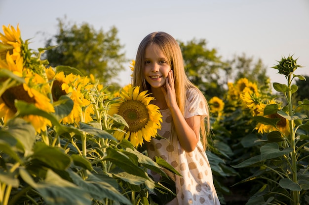 Kleines Mädchen auf dem Feld mit Sonnenblumen verschwommenen Hintergrund