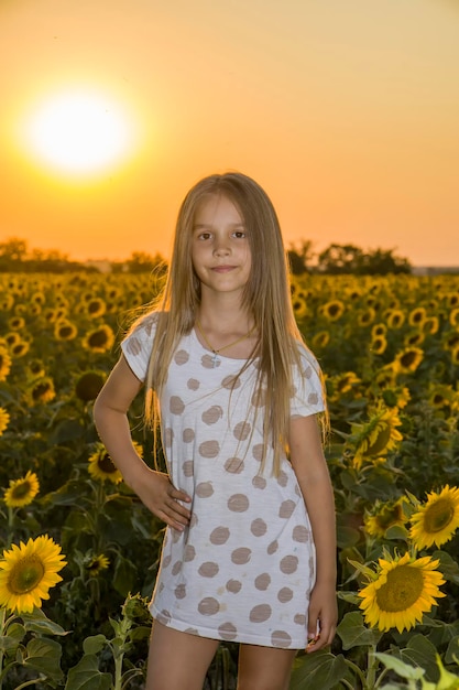 Kleines Mädchen auf dem Feld mit Sonnenblumen verschwommenen Hintergrund