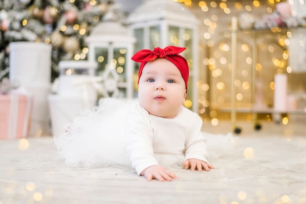 Kleines Mädchen auf dem Hintergrund der Weihnachtsbeleuchtung