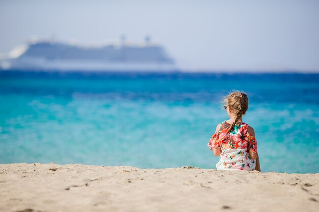 Kleines Mädchen auf der großen Zwischenlage des Strandhintergrundes