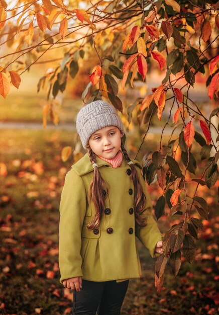 Kleines Mädchen auf einem Hintergrund des Herbstlaubs. traurig