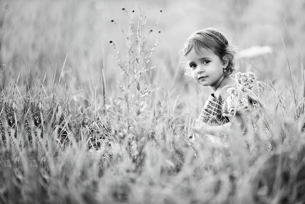 Kleines Mädchen auf einem Sommerweizengebiet. Schwarz-Weiß-Foto