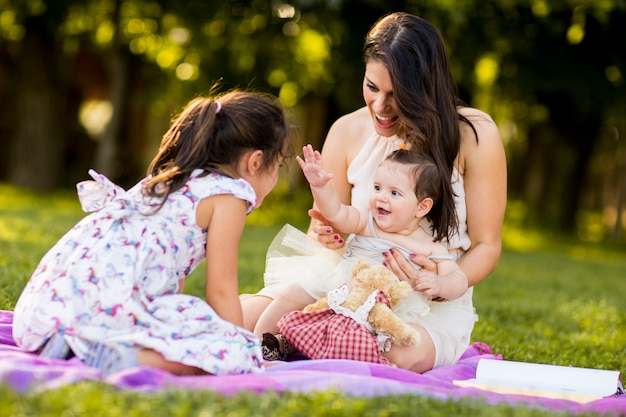 Kleines Mädchen, Baby und Mutter im Freien