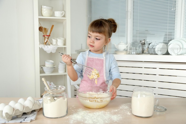 Kleines Mädchen bereitet zu Hause in der Küche Kekse zu