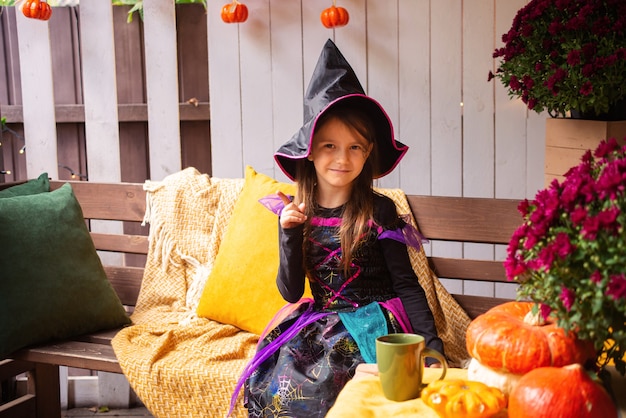 kleines mädchen, das als hexe verkleidet ist, hat spaß mit halloween