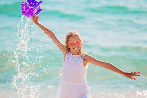 Kleines Mädchen, das am Strand spielt