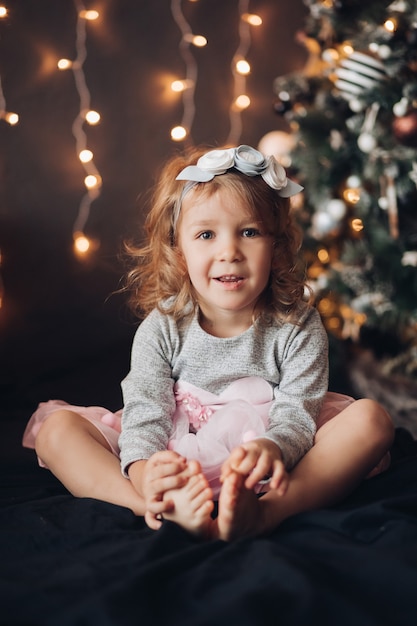 Kleines Mädchen, das am Weihnachtstag aufwirft