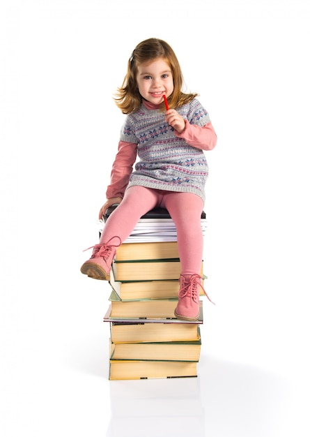 Kleines mädchen, das auf büchern sitzt. zurück zur schule