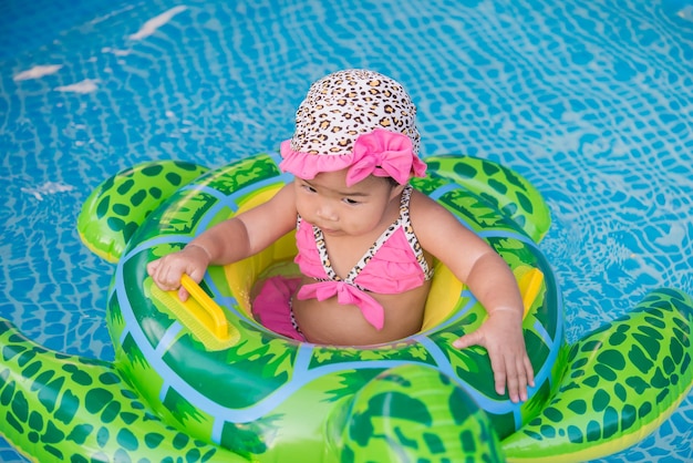 Kleines Mädchen, das auf dem Pool schwimmt
