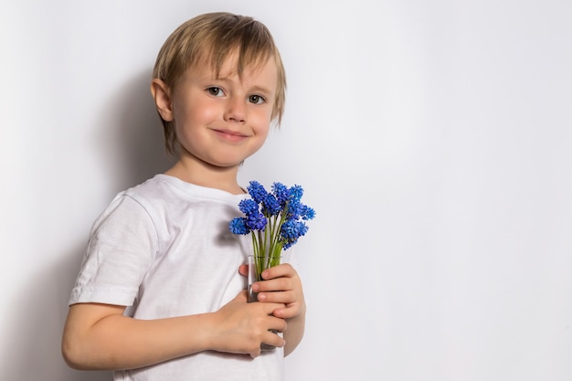 kleines Mädchen, das blauen Blumenstrauß hält