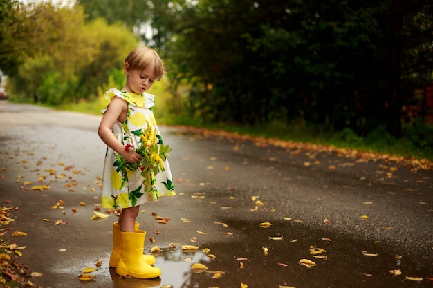 Kleines Mädchen, das Blumen sammelt