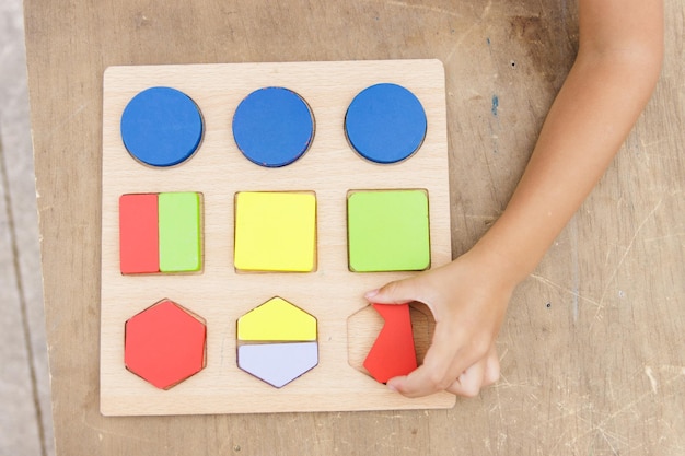 Kleines Mädchen, das buntes Holzpuzzle macht