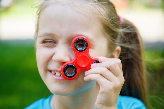 Kleines Mädchen, das draußen einen roten Zappelspinner hält