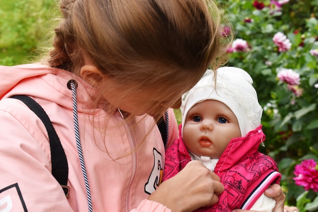 Foto kleines mädchen, das eine babypuppe hält