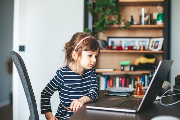 Kleines Mädchen, das einen Laptop verwendet