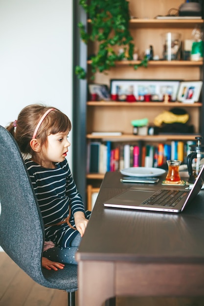 Kleines Mädchen, das einen Laptop verwendet