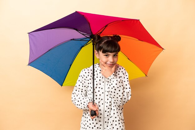 Kleines Mädchen, das einen Regenschirm isoliert hält