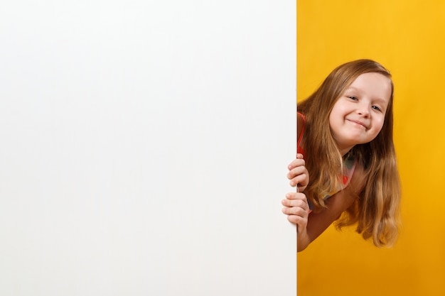 Kleines Mädchen, das einen unbelegten Leerraumhintergrund anhält