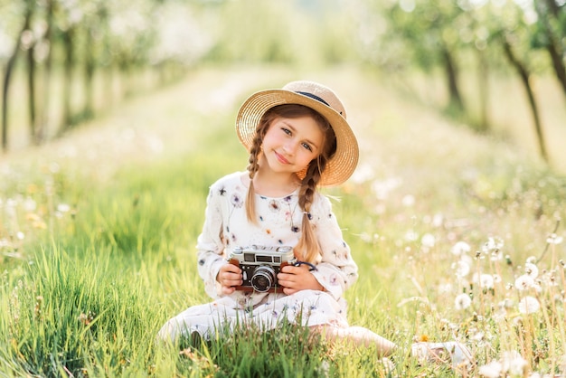 Kleines Mädchen, das Fotos mit einer Weinlesekamera macht