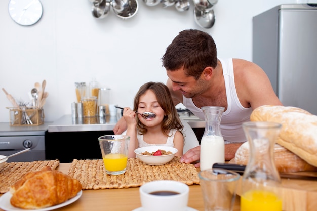 Kleines Mädchen, das ihr Frühstück mit ihrem Vater genießt