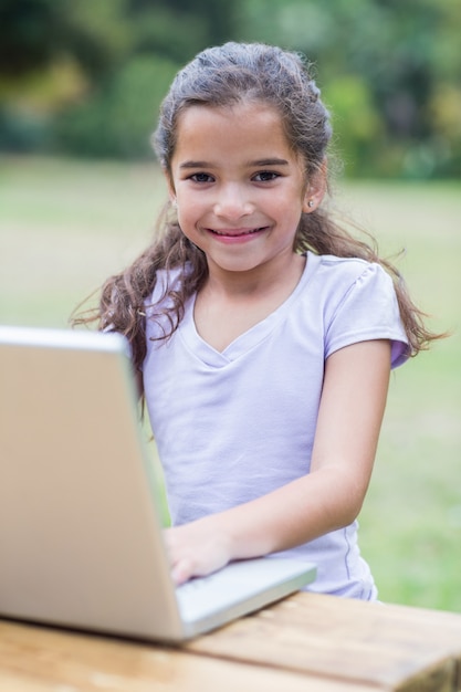 Kleines Mädchen, das ihren Laptop verwendet