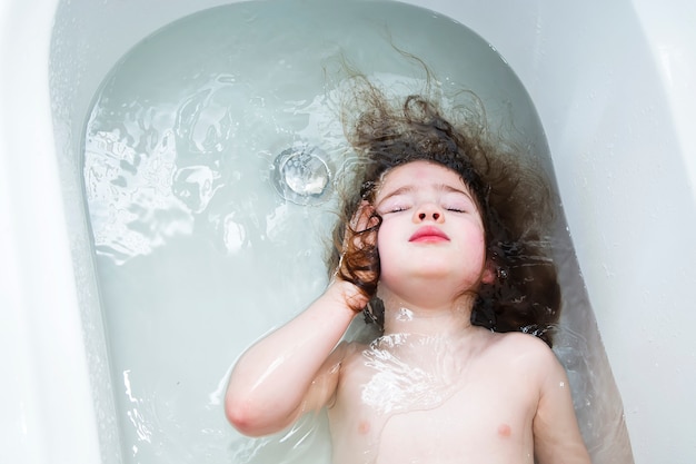 Kleines Mädchen, das im Badezimmer schwimmt