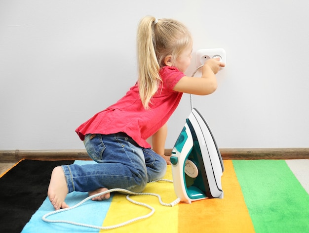 Foto kleines mädchen, das im kinderzimmer mit eisen spielt