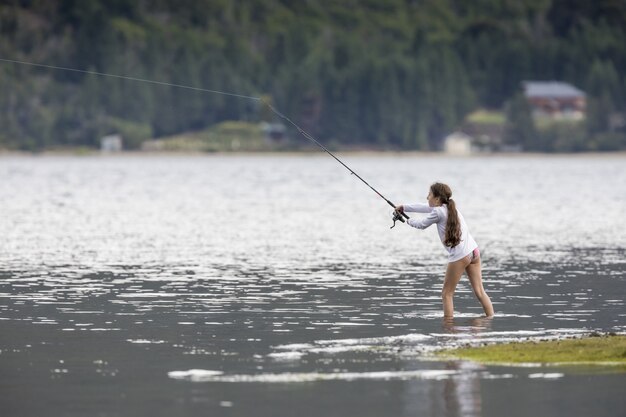 Kleines Mädchen, das im See fischt