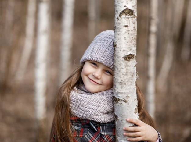 Kleines Mädchen, das im Wald aufwirft