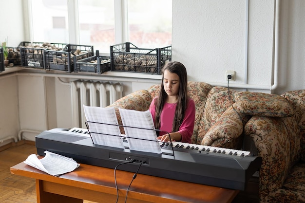 kleines Mädchen, das in einem zerstörten Raum Klavier spielt.