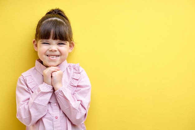 Foto kleines mädchen, das kaukasisches mädchen lacht, vermasselt die augen vor lachen süßes kaukasisches kind im blusenisolat