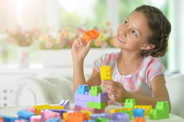 Kleines Mädchen, das mit bunten Plastikblöcken spielt