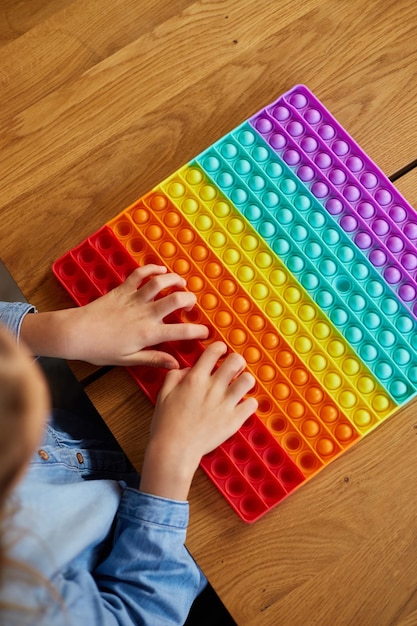 Kleines Mädchen, das mit großem Silikonpopit spielt, einfaches Grübchen, Blasenzappelspielzeug